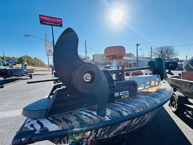 Slide: The Image of 2024 Avid 19XB boat with Minn Kota Ultrex motor in outdoor dealership setting. - 5