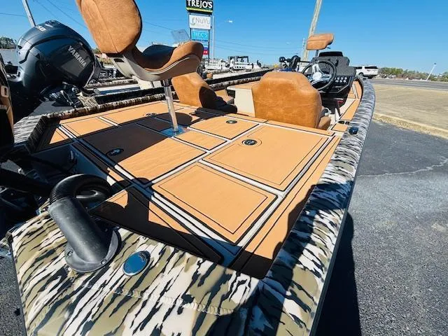 Slide: The Image of 2024 Avid 19XB boat with patterned deck and seating, parked outdoors. - 6