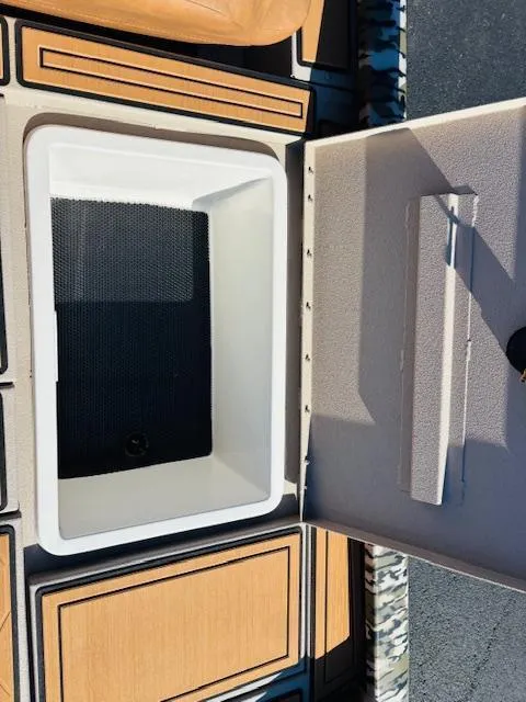 Slide: The Image of 2024 Avid 19XB boat storage compartment with open lid, showcasing interior design. - 7