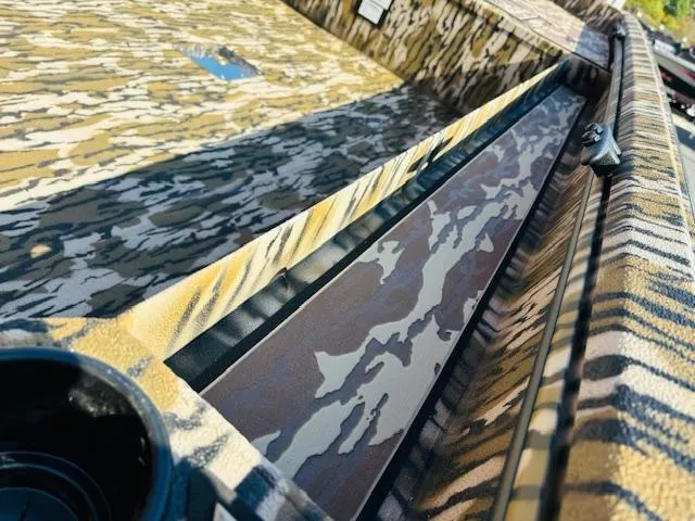 Slide: The Image of Camouflage-patterned interior of 2025 Avid 16COM boat, showcasing sleek design and detail. - 10