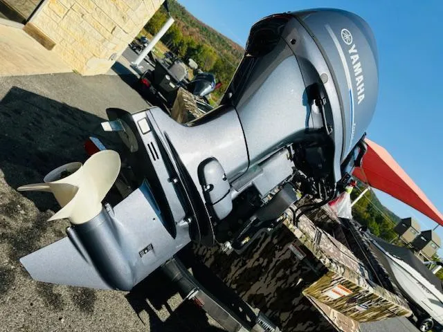 Slide: The Image of Avid 16COM 2025 boat with Yamaha outboard motor, parked outdoors. - 12
