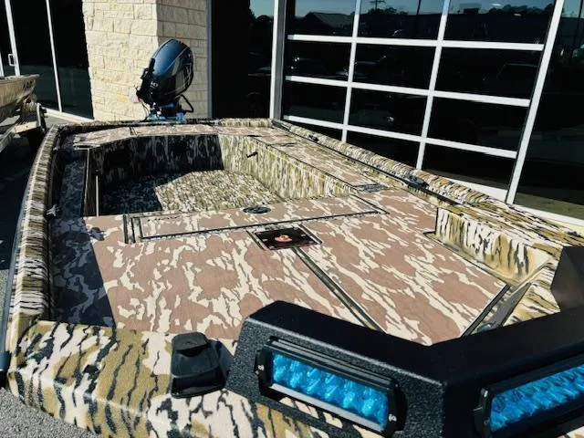 Slide: The Image of Avid 16COM 2025 boat with camouflage design and blue LED lights. - 2