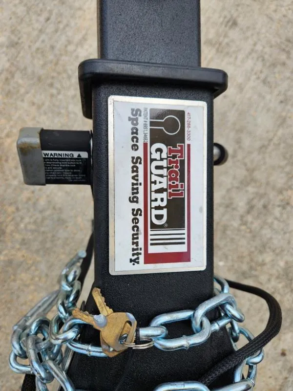 Slide: The Image of 2024 G3 17 SC Trail Guard hitch with security chain and keys. - 24