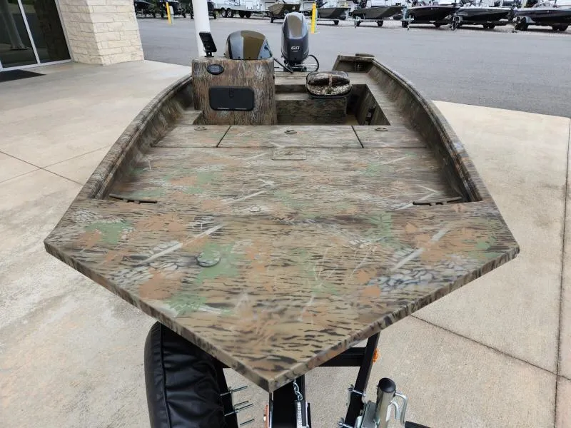 Slide: The Image of 2024 G3 17 SC boat with camouflage design, parked outdoors. - 3