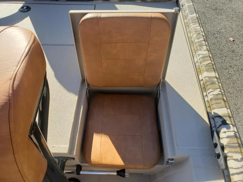 Slide: The Image of 2024 Avid Rogue 20 CC boat seat with tan upholstery and storage compartment. - 11