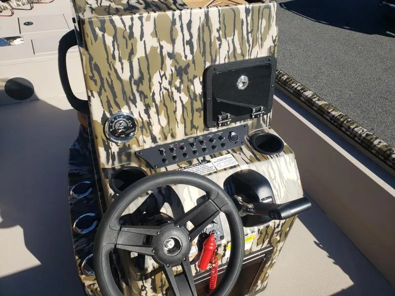 Slide: The Image of 2024 Avid Rogue 20 CC boat console with camouflage design and steering wheel. - 13