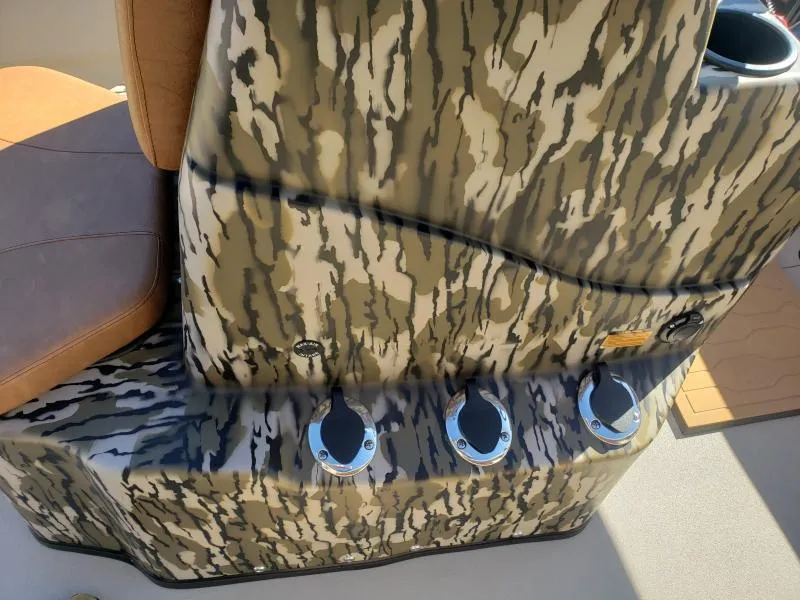 Slide: The Image of 2024 Avid Rogue 20 CC boat console with camouflage design and cup holders. - 16