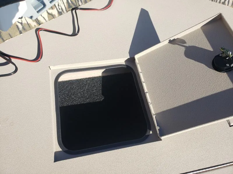 Slide: The Image of Open hatch on 2024 Avid Rogue 20 CC boat deck, showing interior compartment. - 20
