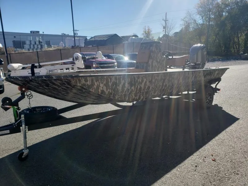 Slide: The Image of 2024 Avid Rogue 20 CC boat with camouflage design parked outdoors. - 4