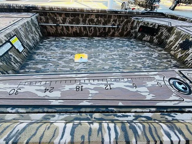 Slide: The Image of Avid 16 Commander 2025 boat interior with camouflage design and measuring ruler. - 12