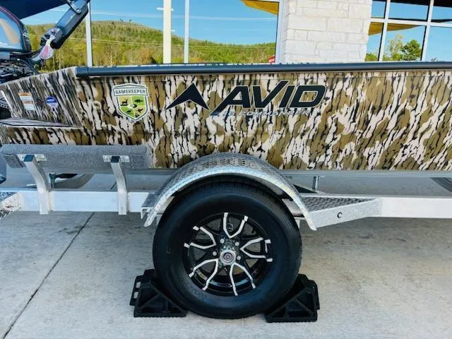 Slide: The Image of Avid 16 Commander 2025 boat with camo design on a trailer. - 14