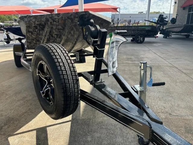 Slide: The Image of 2024 Havoc Boats 1550 VJ on trailer, camo design, displayed outdoors. - 9