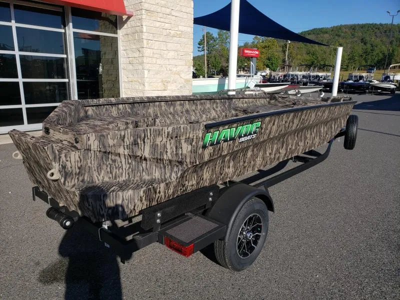 Slide: The Image of 2024 Havoc Boats 1756 Dbst in camouflage design on a trailer, outdoor display. - 12