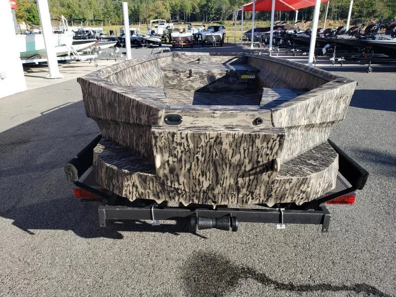 Slide: The Image of 2024 Havoc Boats 1756 Dbst with camouflage design on a trailer, parked outdoors. - 13