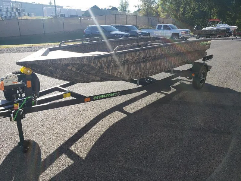 Slide: The Image of 2024 Havoc Boats 1756 Dbst on trailer, camo design, parked outdoors. - 16