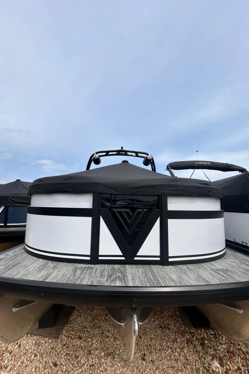 Slide: The Image of 2025 Viaggio Lago X-R boat with sleek design, docked on gravel. - 2