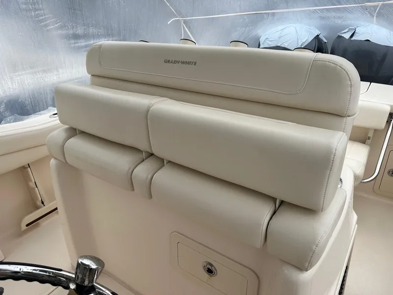 Slide: The Image of 2020 Grady-White 271 Canyon boat interior with beige seating and steering wheel. - 2