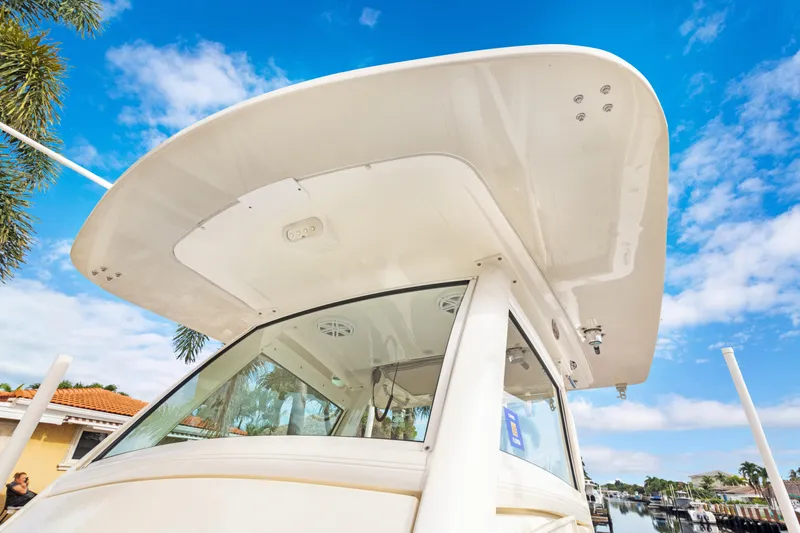 Slide: The Image of 2018 Scout 320 LXF boat with sleek design under a clear blue sky. - 10