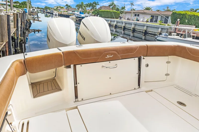 Slide: The Image of 2018 Scout 320 LXF boat interior with Yamaha engines, docked in a scenic canal. - 29