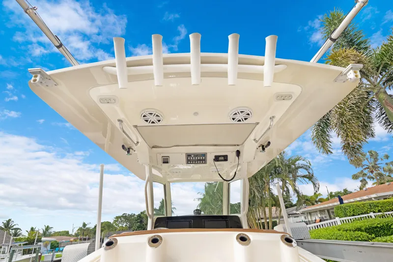 Slide: The Image of 2018 Scout 320 LXF boat with rod holders and speakers under a clear blue sky. - 32