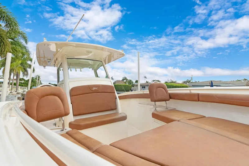 Slide: The Image of 2018 Scout 320 LXF boat with brown seating, clear sky background. - 37
