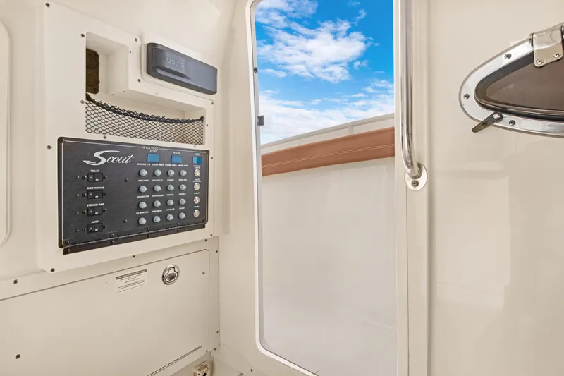 Slide: The Image of 2018 Scout 320 LXF boat interior with control panel and open door to blue sky. - 40