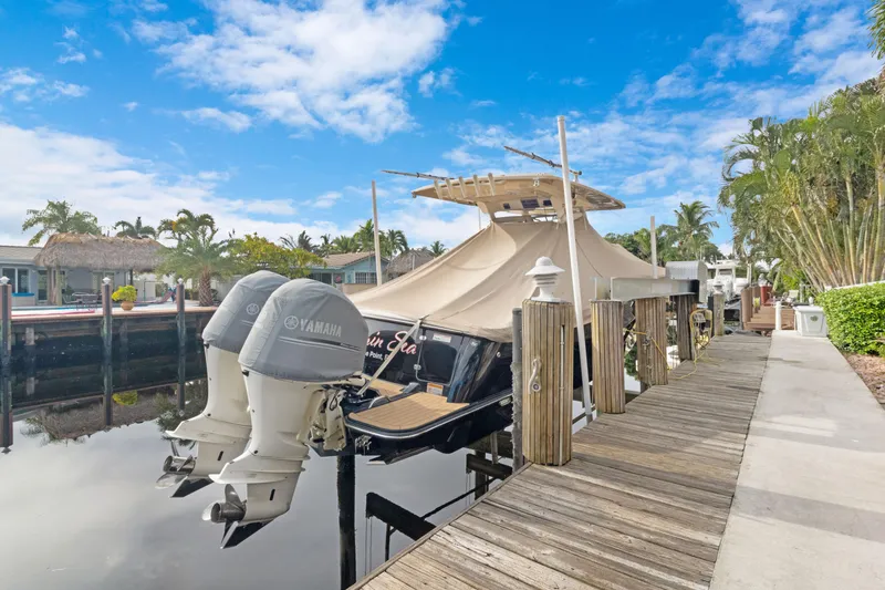 Slide: The Image of 2018 Scout 320 LXF boat docked with Yamaha engines, under a clear blue sky. - 46