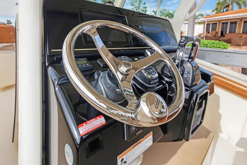 Slide: The Image of Steering wheel and controls of a 2018 Scout 320 LXF boat. - 6