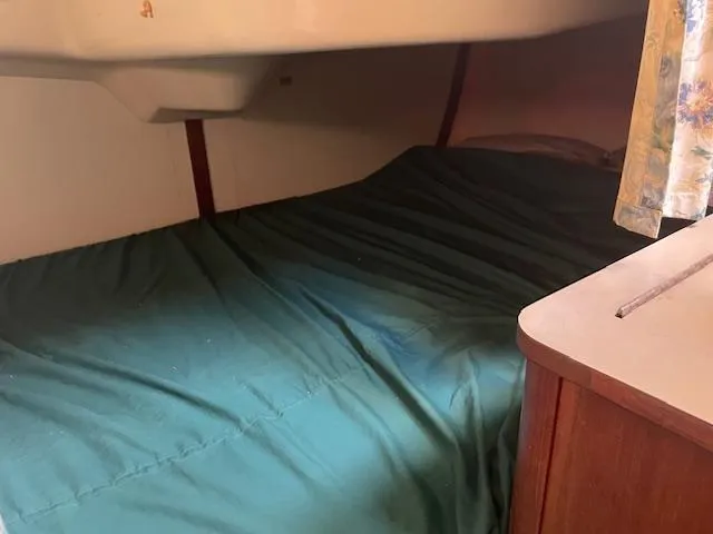 Slide: The Image of Interior cabin of a 1991 Hunter 30T sailboat with green bedding. - 11