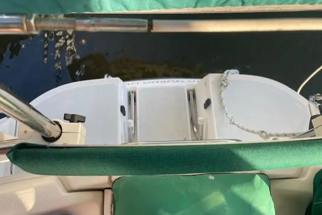 Slide: The Image of 1991 Hunter 30T sailboat stern view with green seating and water backdrop. - 24