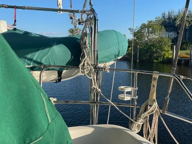 Slide: The Image of Sailboat deck view, Hunter 30T 1991, with green covers and ropes by the water. - 25