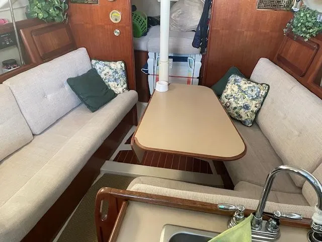 Slide: The Image of Interior of a 1991 Hunter 30T sailboat with cozy seating and a central table. - 4