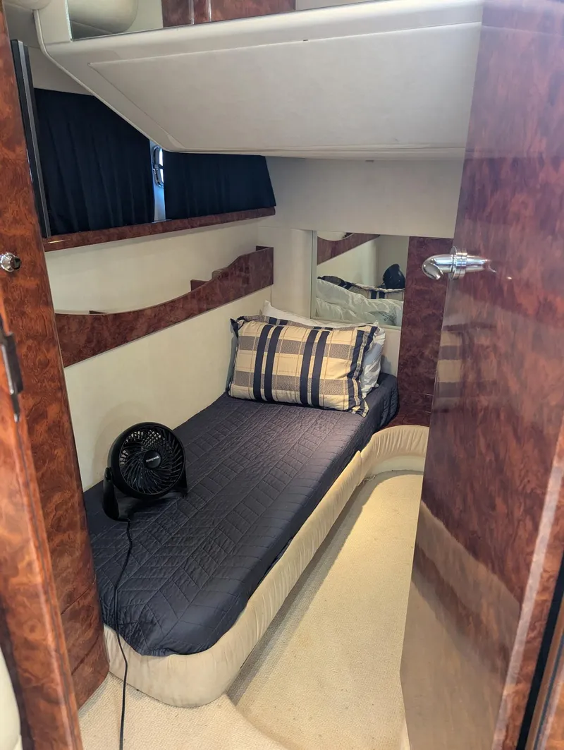 Slide: The Image of 2007 Fairline Targa 52 GT cabin with single bed, fan, and wooden accents. - 10