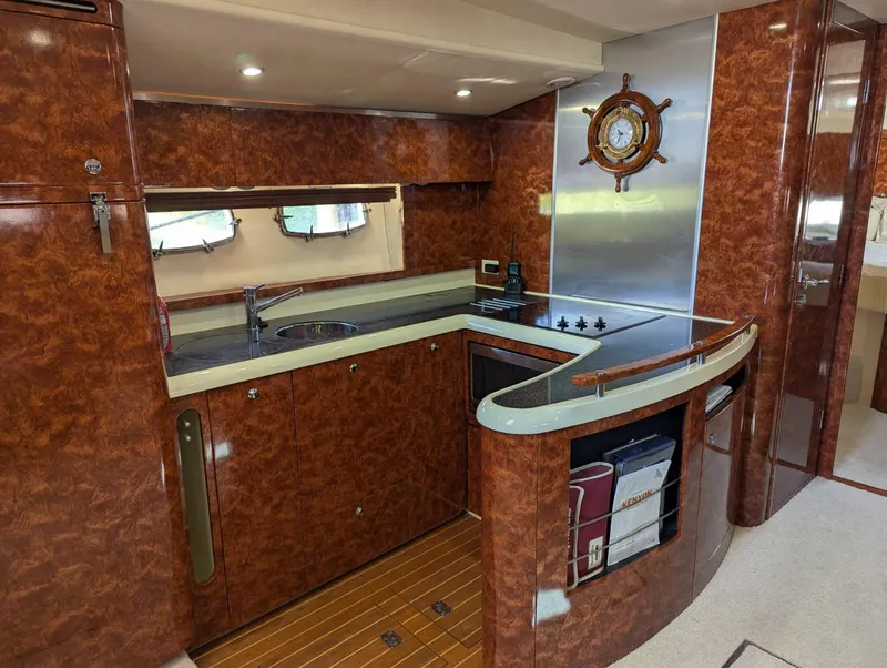 Slide: The Image of 2007 Fairline Targa 52 GT yacht interior with elegant wood-finish kitchen and modern amenities. - 8