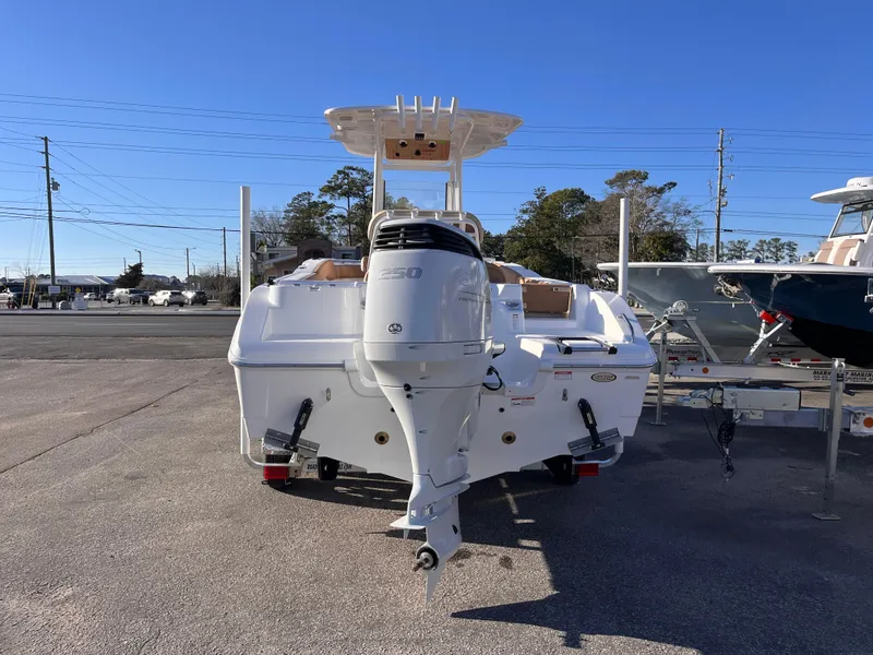 Slide: The Image of 2025 NauticStar 242L Offshore boat with outboard motor, parked on a sunny day. - 3