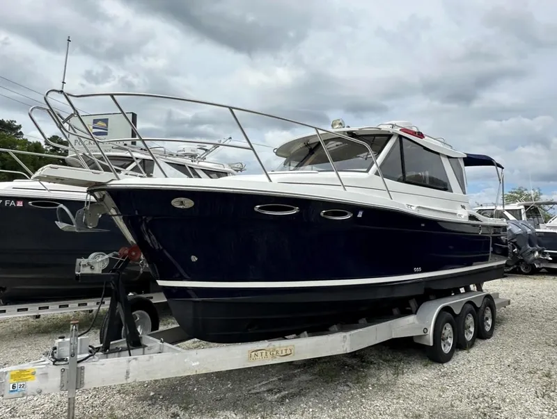 Slide: The Image of 2016 Cutwater C-26 boat on a trailer, parked outdoors under cloudy skies. - 1