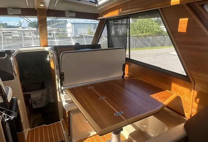 Slide: The Image of Interior of 2016 Cutwater C-26 boat with wooden table and seating area. - 15