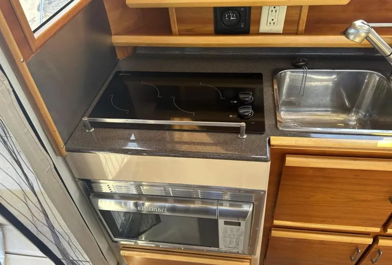 Slide: The Image of Compact kitchen in a 2016 Cutwater C-26 boat with stove, sink, and microwave. - 19