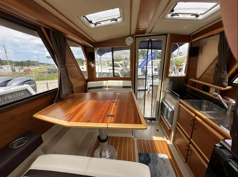 Slide: The Image of Interior of 2016 Cutwater C-26 boat with wooden table and kitchenette. - 20