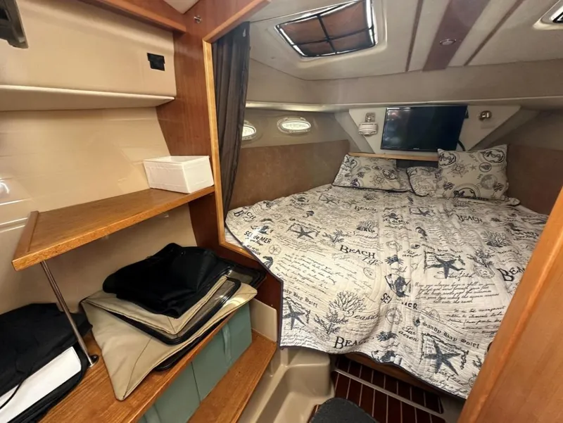 Slide: The Image of 2016 Cutwater C-26 cabin interior with cozy bed and wooden shelving. - 24