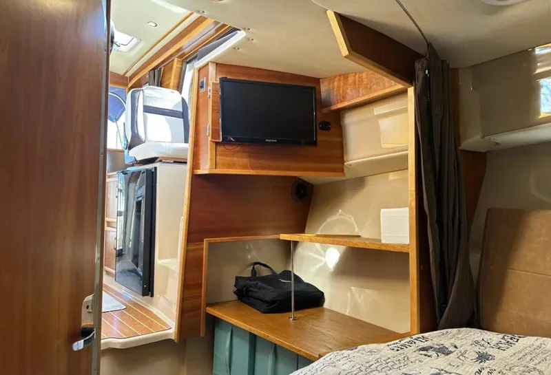 Slide: The Image of 2016 Cutwater C-26 cabin interior with TV, shelves, and bed. - 25