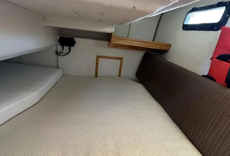 Slide: The Image of 2016 Cutwater C-26 cabin interior with bed, window, and storage shelf. - 26