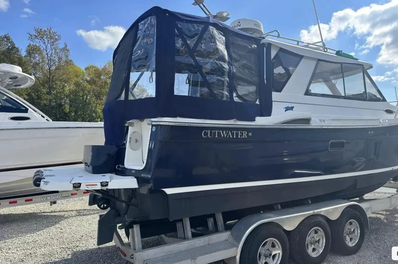 Slide: The Image of 2016 Cutwater C-26 boat on trailer, blue hull, parked outdoors under clear sky. - 3