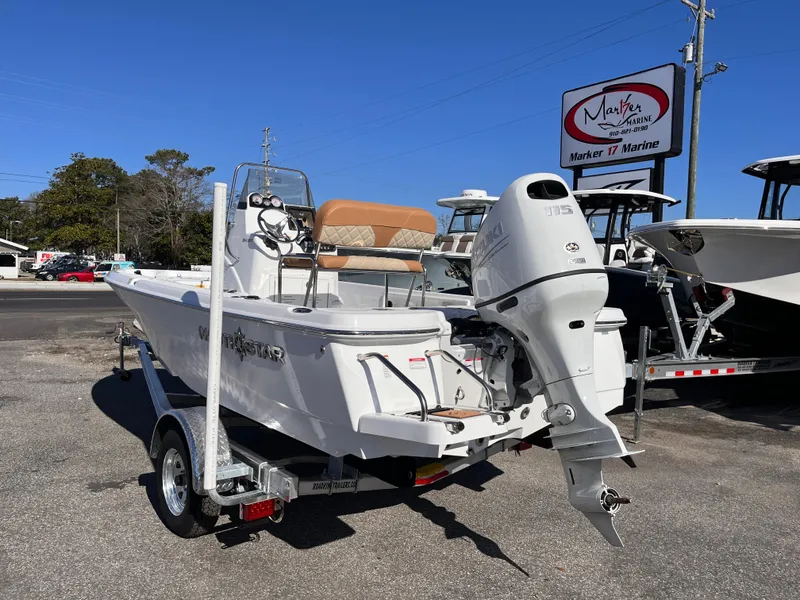 Slide: The Image of 2025 NauticStar 194 Bay boat on trailer at marina, rear view. - 2