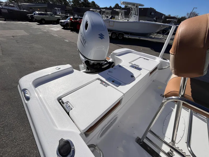 Slide: The Image of 2025 NauticStar 194 Bay boat with outboard motor in a marina setting. - 5
