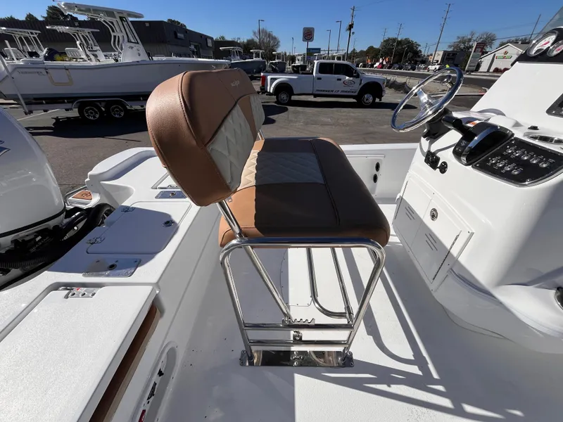 Slide: The Image of 2025 NauticStar 194 Bay boat interior with brown seating and steering console. - 6
