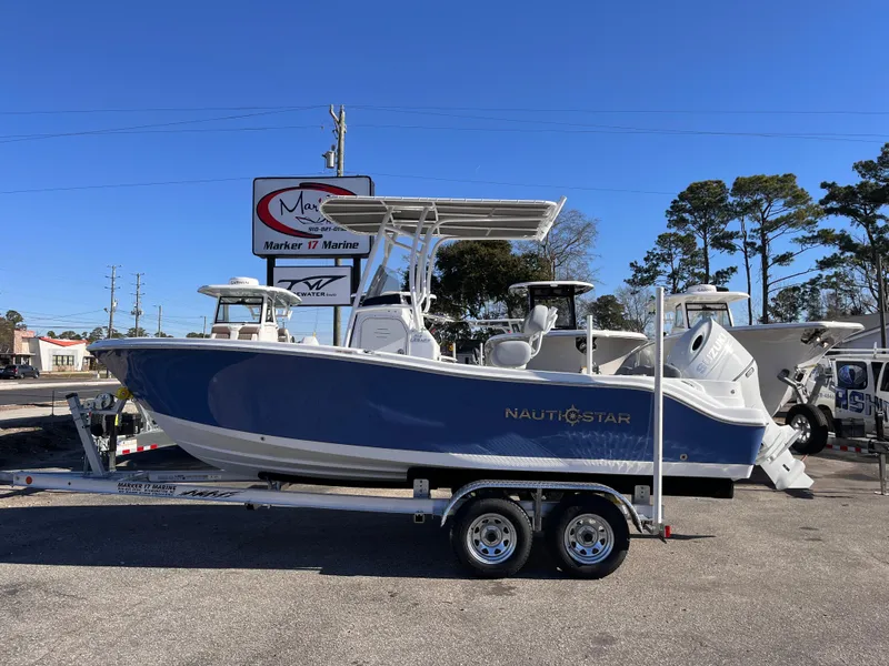 The Image of 2025 NauticStar 212 Legacy boat on trailer, displayed outdoors at a dealership. - 0