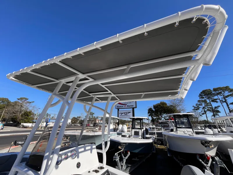 Slide: The Image of 2025 NauticStar 212 Legacy boat with T-top canopy in a marina setting. - 13