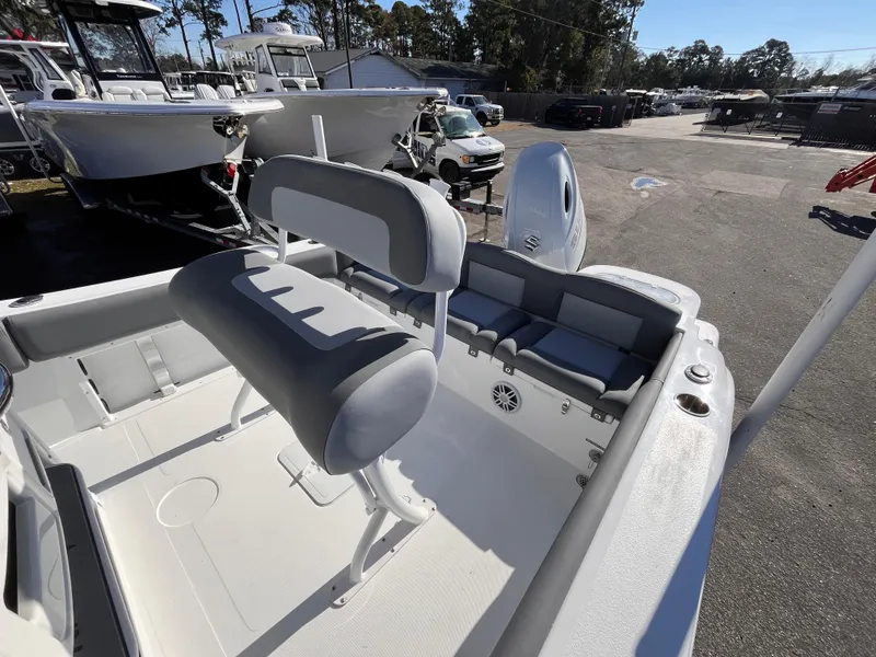 Slide: The Image of 2025 NauticStar 212 Legacy boat interior with seating and motor, displayed outdoors. - 14