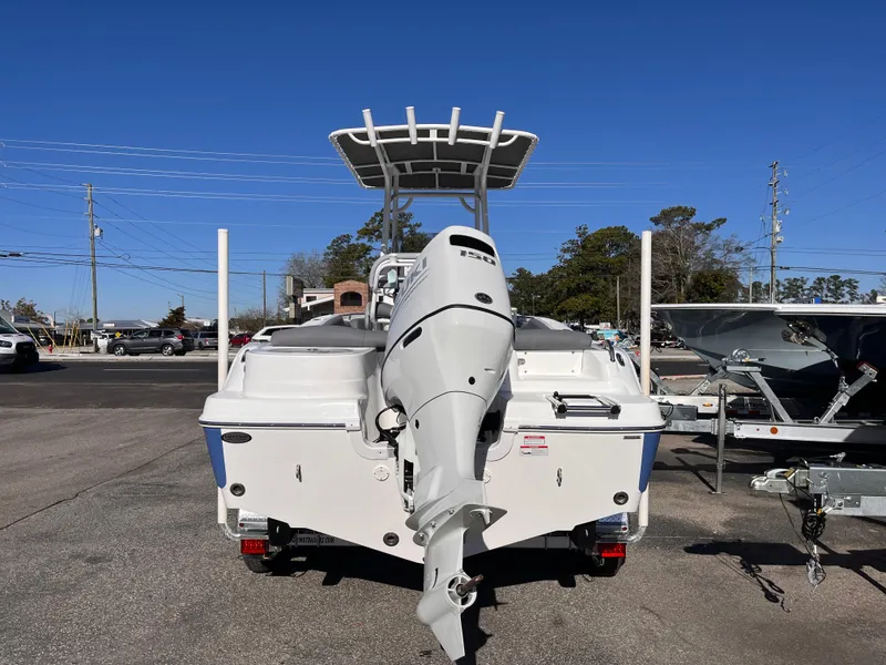 Slide: The Image of 2025 NauticStar 212 Legacy boat with outboard motor, parked on a trailer. - 3